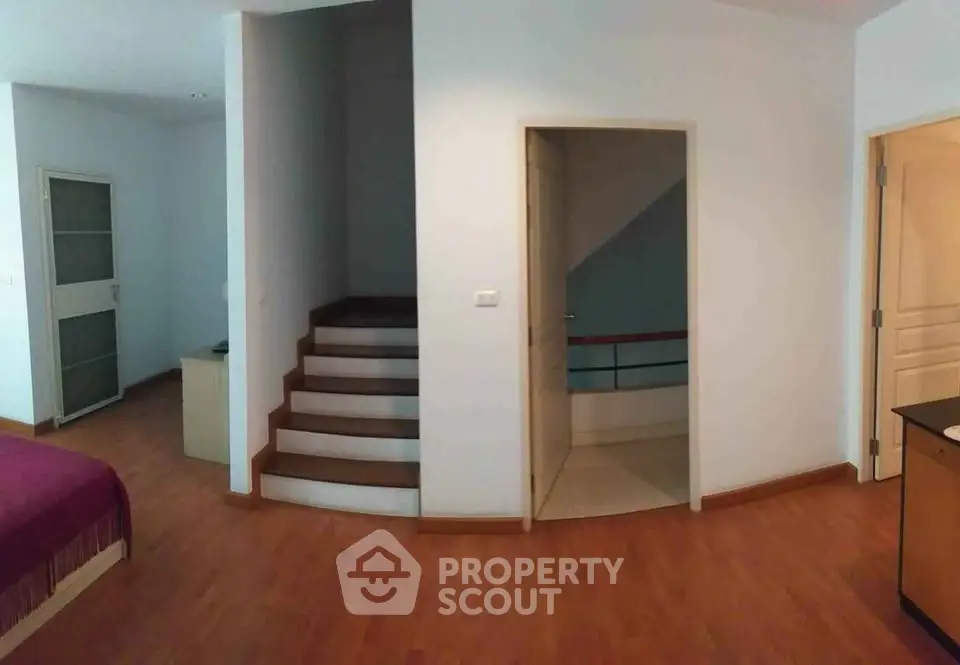 Spacious interior with wooden flooring and staircase in modern home