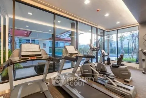 Modern gym with state-of-the-art equipment and large windows offering a scenic view.