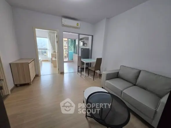 Spacious living room with modern furniture and balcony access in a stylish apartment.