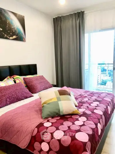 Charming bedroom with vibrant decor and city view from window, perfect for cozy living.