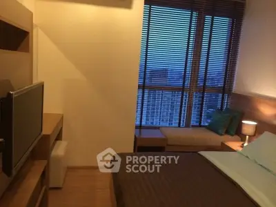 Cozy bedroom with city view, featuring modern decor and large window with blinds.