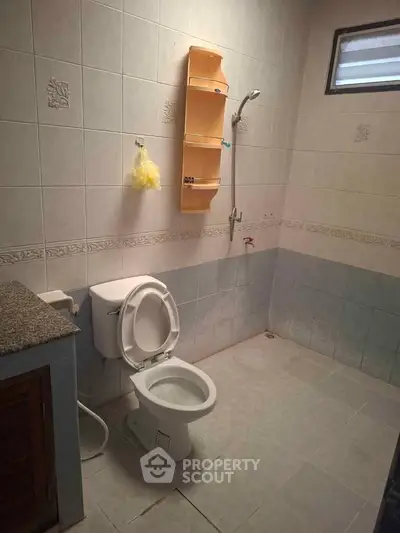 Spacious bathroom with tiled walls, shower, and toilet in a modern home.