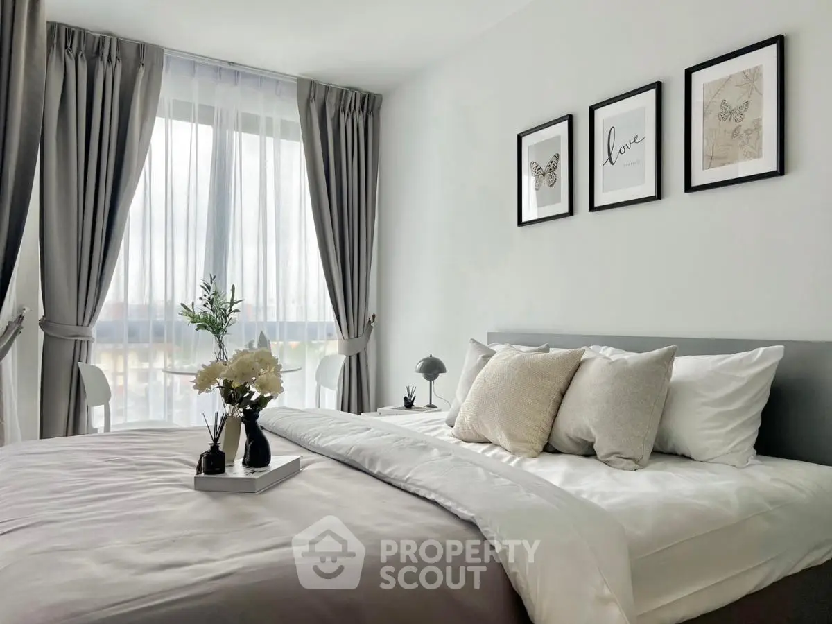 Elegant bedroom with modern decor and large window for natural light.