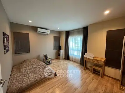 Spacious bedroom with wooden flooring and natural light in modern apartment