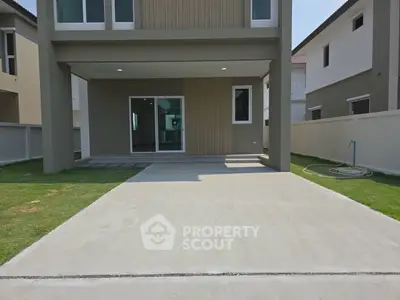 Modern house exterior with spacious driveway and manicured lawn