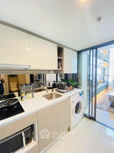 Modern kitchen with sleek appliances and washing machine in stylish apartment