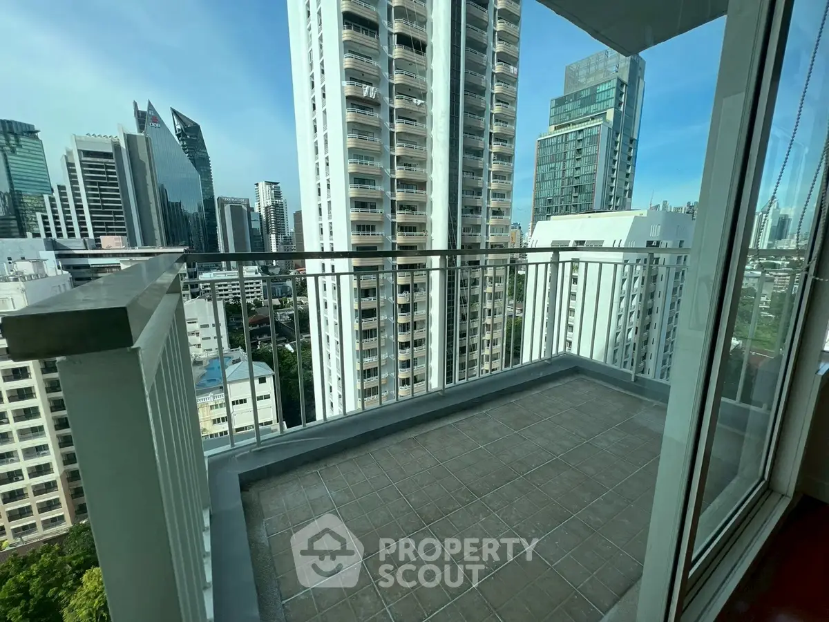Spacious balcony with stunning cityscape views in a modern high-rise building.