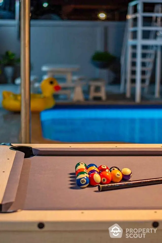 Luxurious poolside area with billiards table and inflatable duck, perfect for entertainment and relaxation.