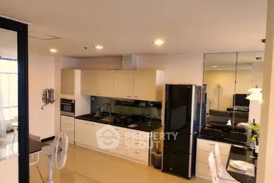 Modern kitchen with sleek black appliances and open layout in a stylish apartment.