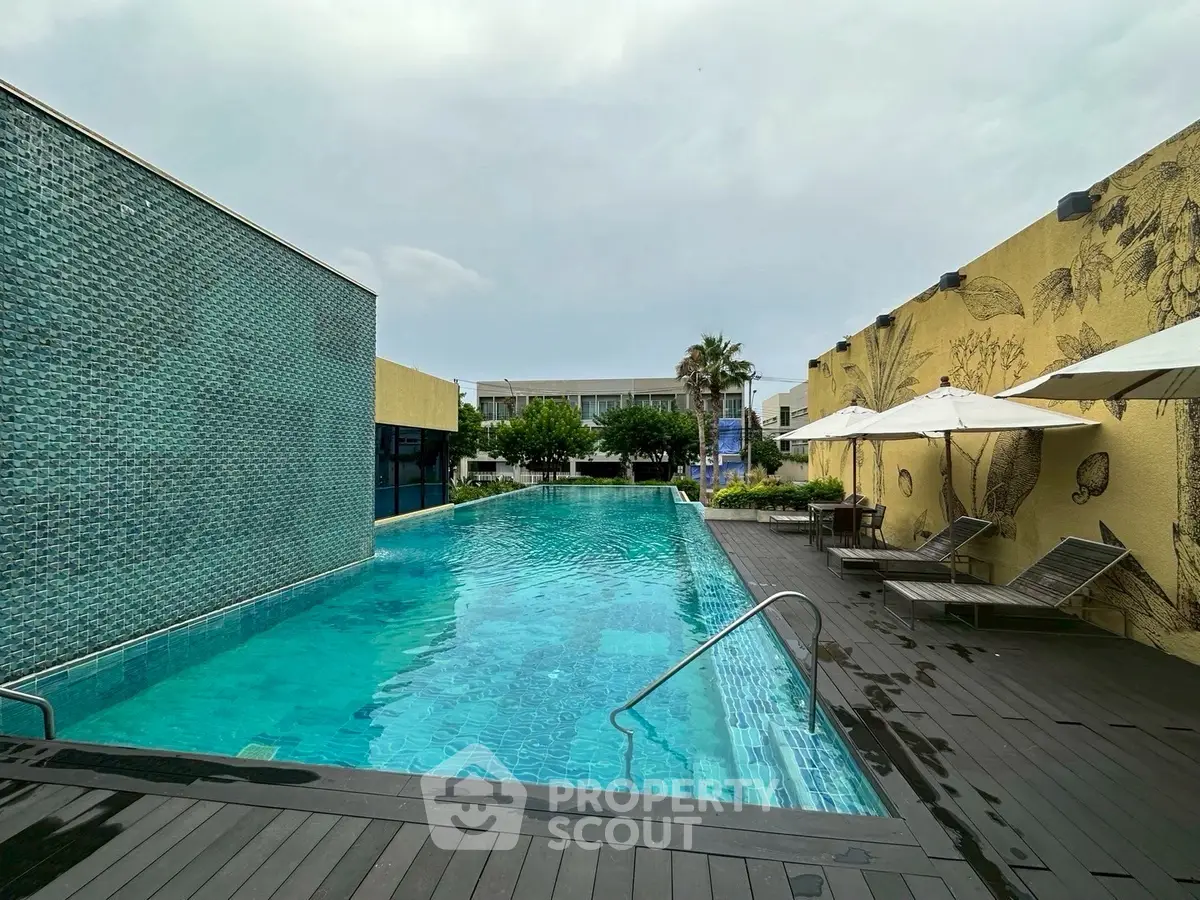 Luxurious outdoor pool area with stylish deck and sun loungers, perfect for relaxation and leisure.