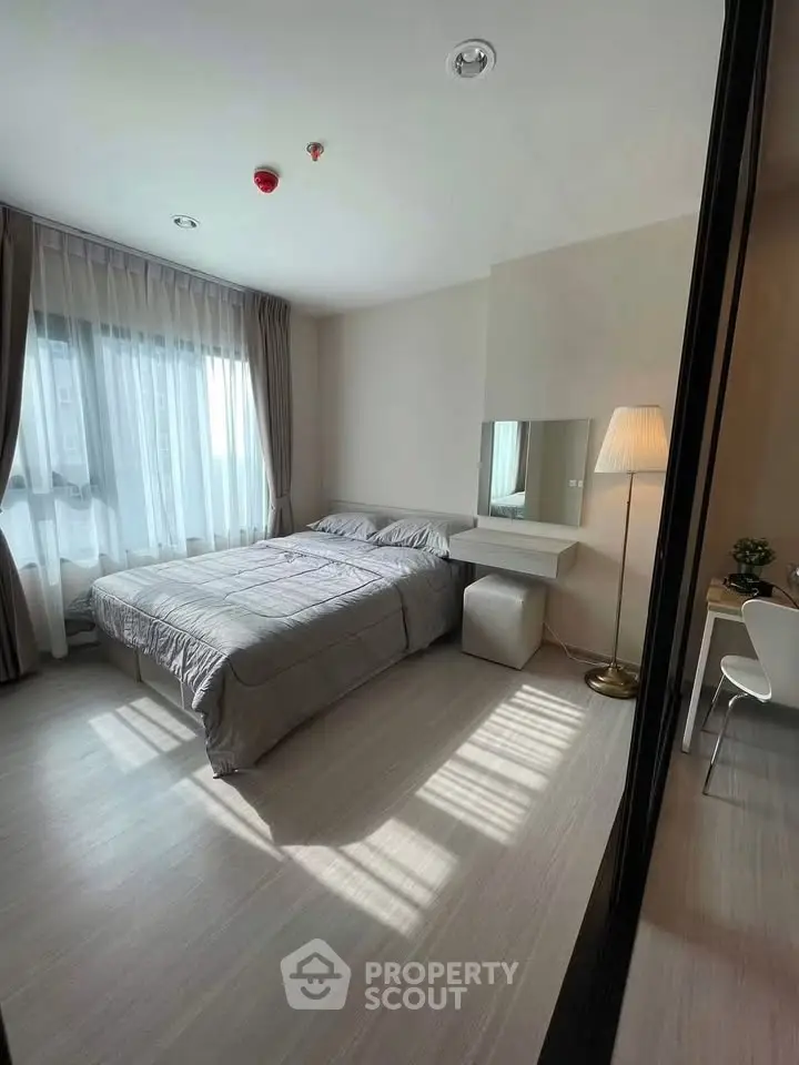 Spacious bedroom with natural light and modern decor in a stylish apartment.