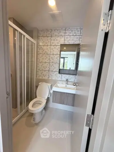 Modern bathroom with sleek design, featuring a glass shower enclosure and stylish vanity.