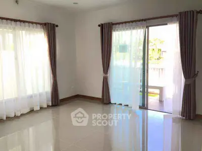 Spacious sunlit room with large windows and sliding glass door leading to a balcony, perfect for natural light lovers.