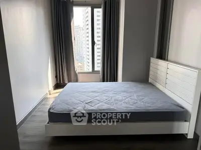 Modern bedroom with large window and city view, featuring sleek design and natural light.