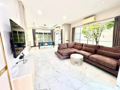 Spacious modern living room with large windows and plush brown sofa