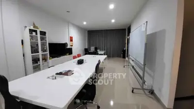 Spacious modern study room with sleek white desks and ample lighting, perfect for productivity.