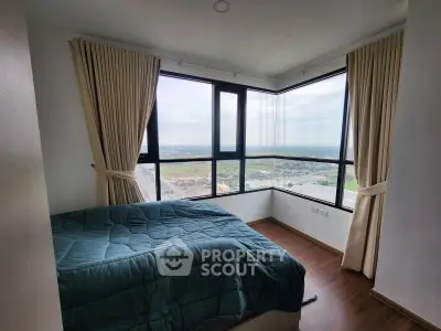 Spacious bedroom with panoramic windows offering stunning views and natural light.