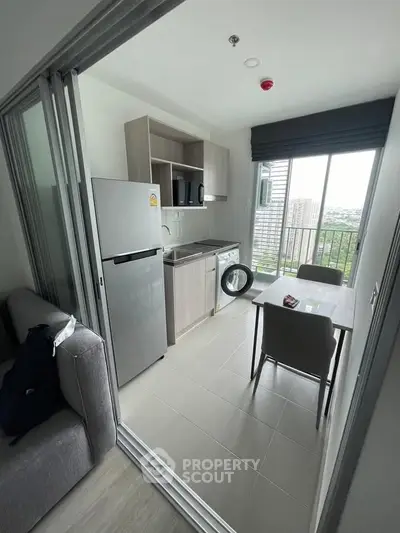 Modern kitchen with open layout, featuring sleek appliances and a scenic view from the window.