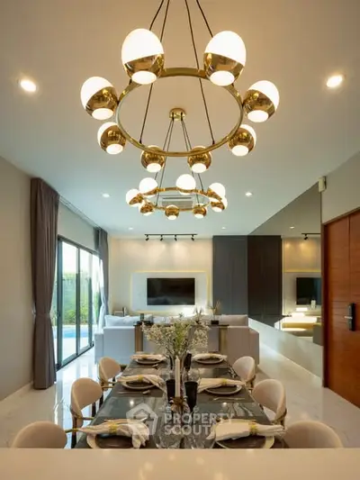 Luxurious open-plan living and dining area with elegant chandelier and modern decor.
