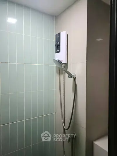 Modern bathroom shower area with sleek tiles and water heater