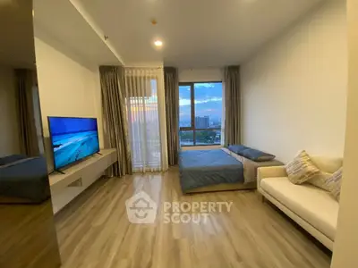 Modern living room with large window and city view, featuring sleek flooring and contemporary furniture.