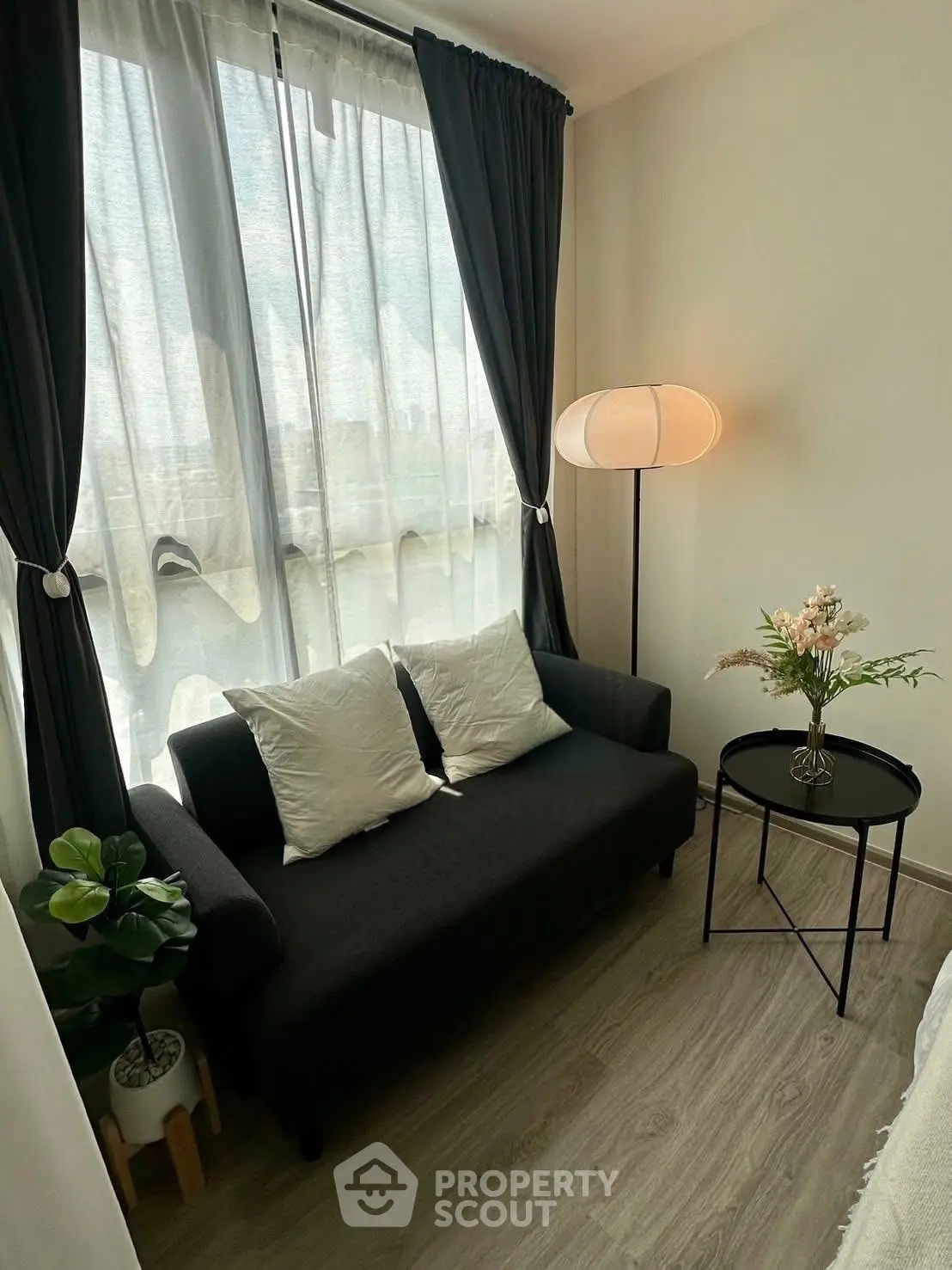Cozy living room with elegant sofa, floor lamp, and stylish decor