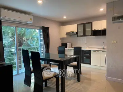 Modern open-layout kitchen and dining area with sleek furniture and natural light.