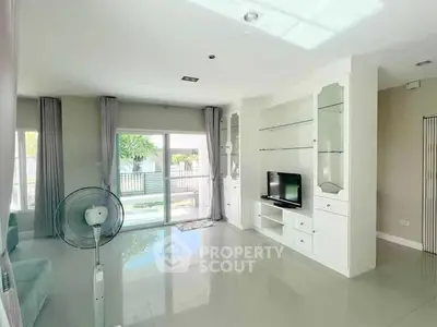 Spacious living room with modern decor and large windows overlooking garden