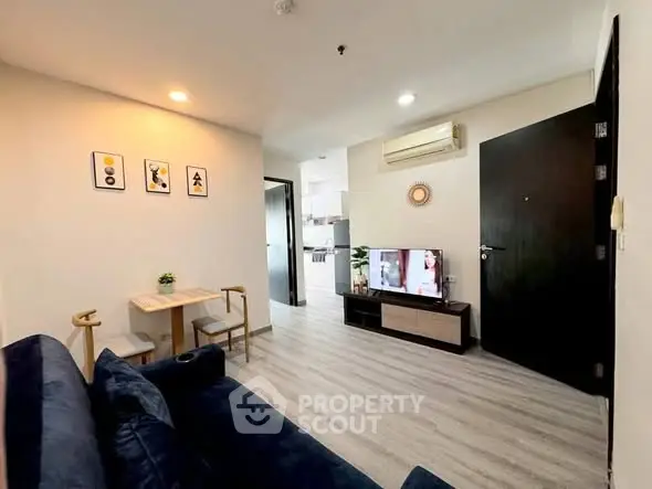 Modern living room with stylish decor and open layout, featuring a cozy seating area and wall-mounted TV.