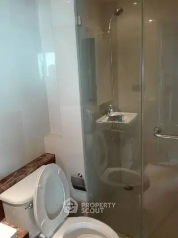 Modern bathroom with glass shower enclosure and sleek fixtures