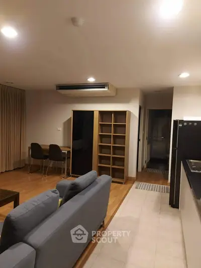 Modern living room with cozy sofa and dining area in open layout apartment.