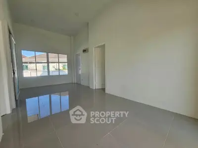 Spacious empty room with large windows and glossy tiled floor in modern home