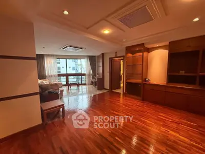 Spacious living room with wooden flooring and modern furniture in a luxury apartment.