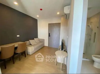 Modern living room with sleek furniture and open layout, featuring a cozy sofa and dining area.