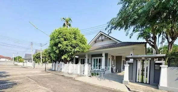 Charming single-story house with lush greenery and spacious driveway in a serene neighborhood.