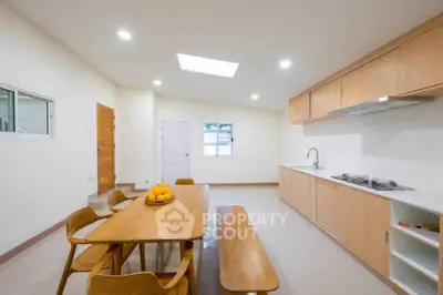 Spacious modern kitchen with wooden dining set and sleek cabinetry
