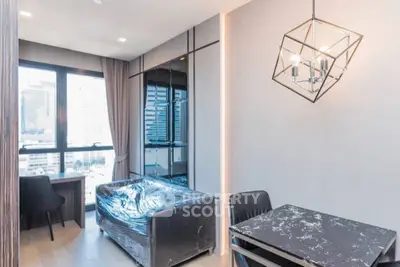 Modern living room with city view, stylish lighting, and sleek furniture in a high-rise apartment.