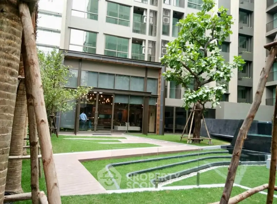 Modern apartment building with lush garden and unique water feature.