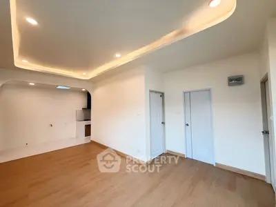 Spacious modern living room with elegant ceiling lights and wooden flooring