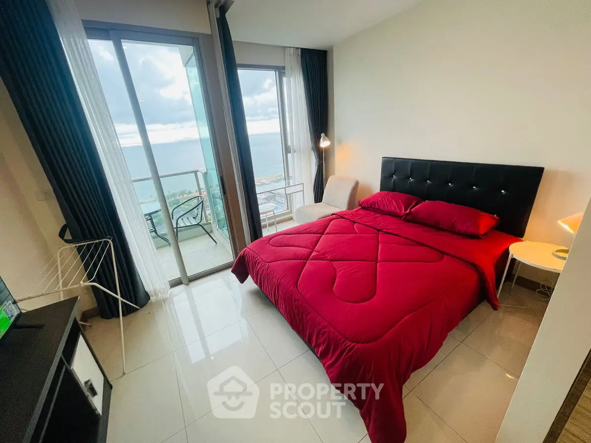 Modern bedroom with ocean view and balcony access in luxury apartment