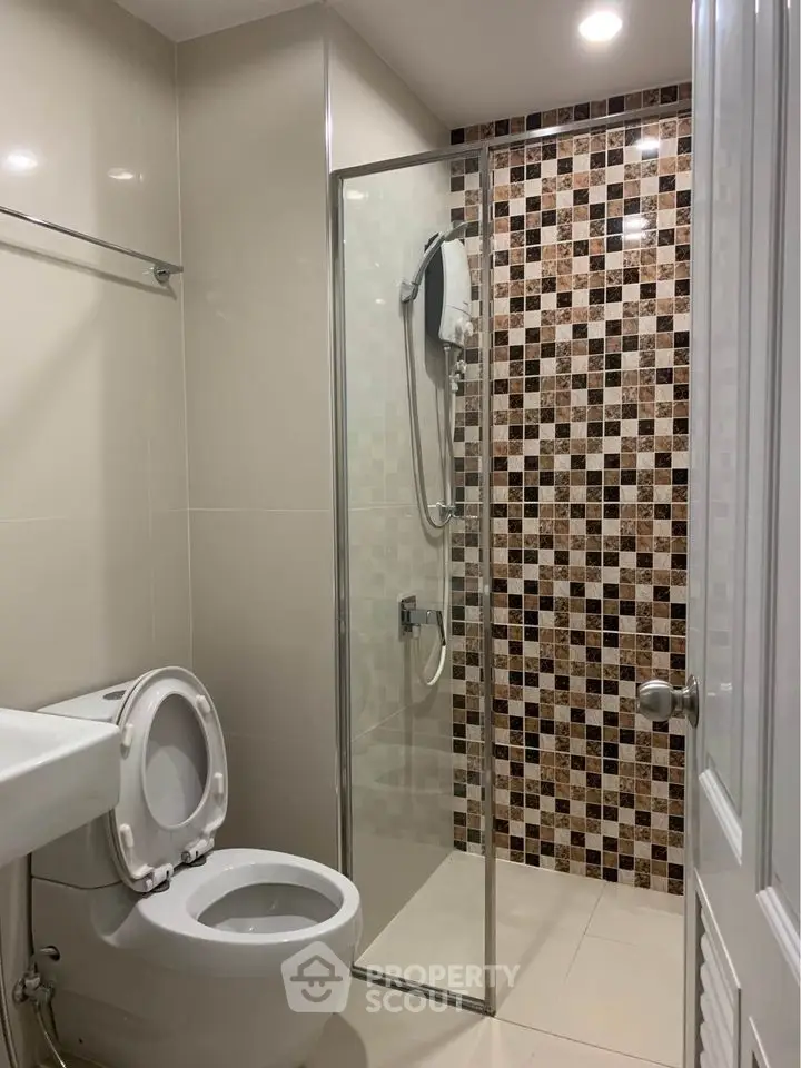 Modern bathroom with glass shower and mosaic tile design
