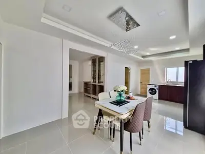 Modern dining area with elegant chandelier and open kitchen layout