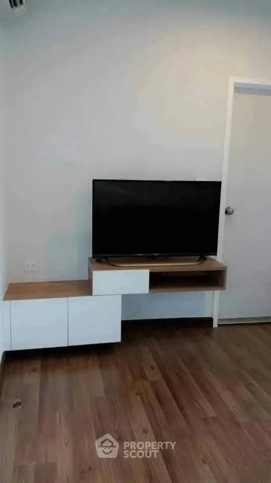Modern living room with sleek TV stand and wooden flooring, perfect for cozy entertainment setup.