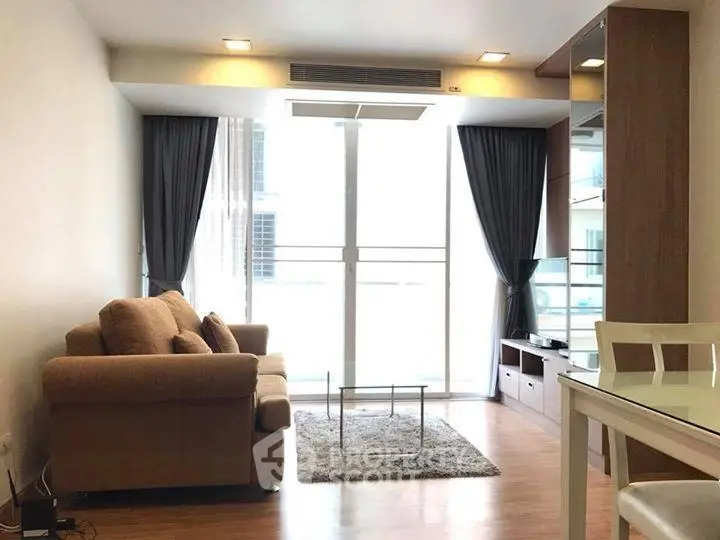Modern living room with cozy sofa and large window in stylish apartment.