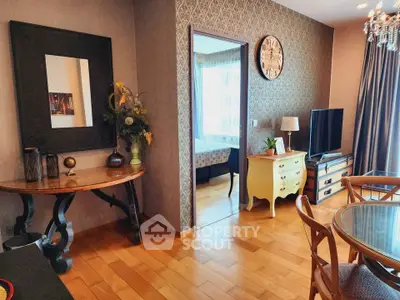 Charming living room with elegant decor and wooden flooring, featuring a stylish TV setup and dining area.