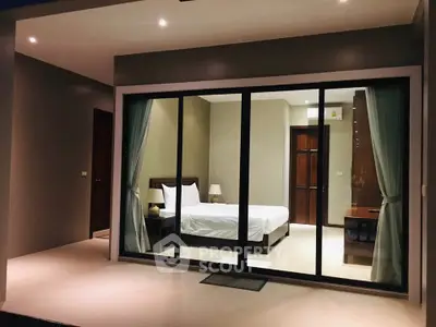 Modern bedroom with large glass doors and elegant interior design.