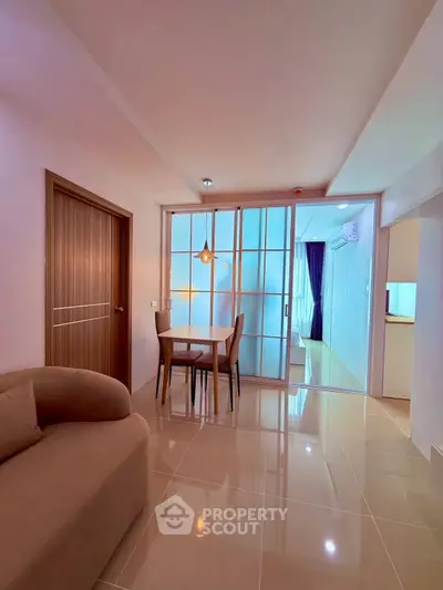 Modern living room with sleek furniture and glass partition in stylish apartment.