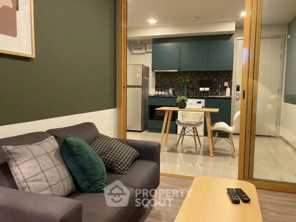 Modern living room with cozy sofa and stylish kitchen in open layout apartment.