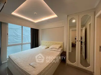 Modern bedroom with elegant lighting and mirrored wardrobe in a stylish apartment.