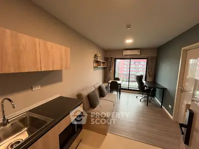 Modern living room with balcony, featuring sleek furniture and natural light.